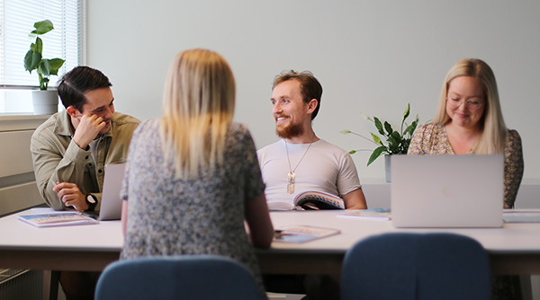 Fire unge omkring et arbejdsbord